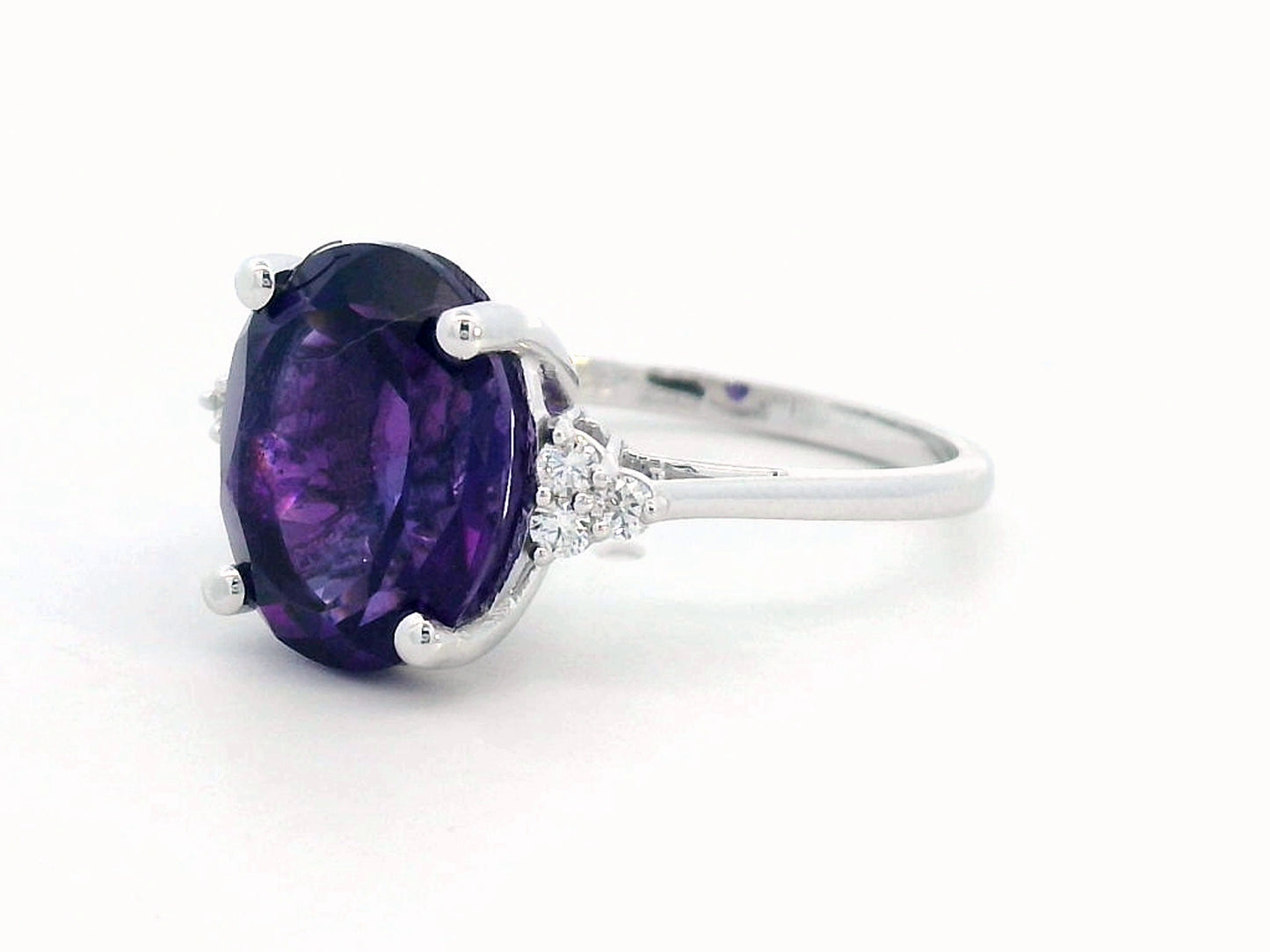 18K gold ring featuring a 4.37-carat oval-cut amethyst, accented by 0.13 carats of round diamonds.