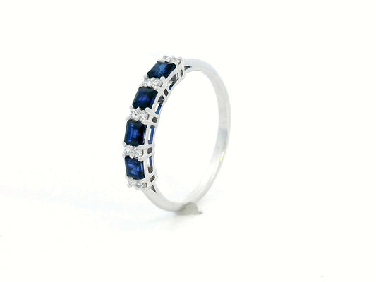 18K white gold sapphire and diamond eternity ring featuring princess-cut blue sapphires and round white diamonds in a half-eternity design.