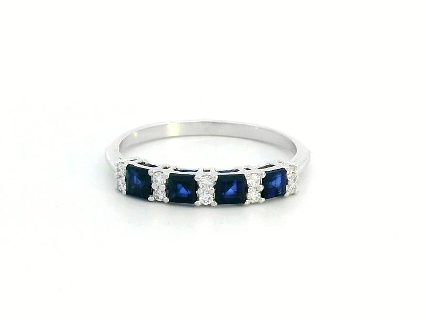 18K white gold sapphire and diamond eternity ring featuring square-cut blue sapphires and round white diamonds in a half-eternity design.