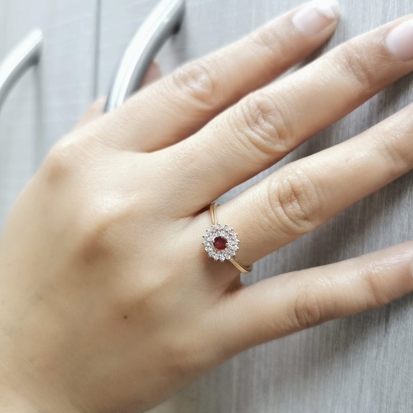 18K gold ruby and diamond halo ring featuring a 0.20-carat deep red ruby and 0.22-carat diamond halo – a vintage-inspired birthstone and engagement ring