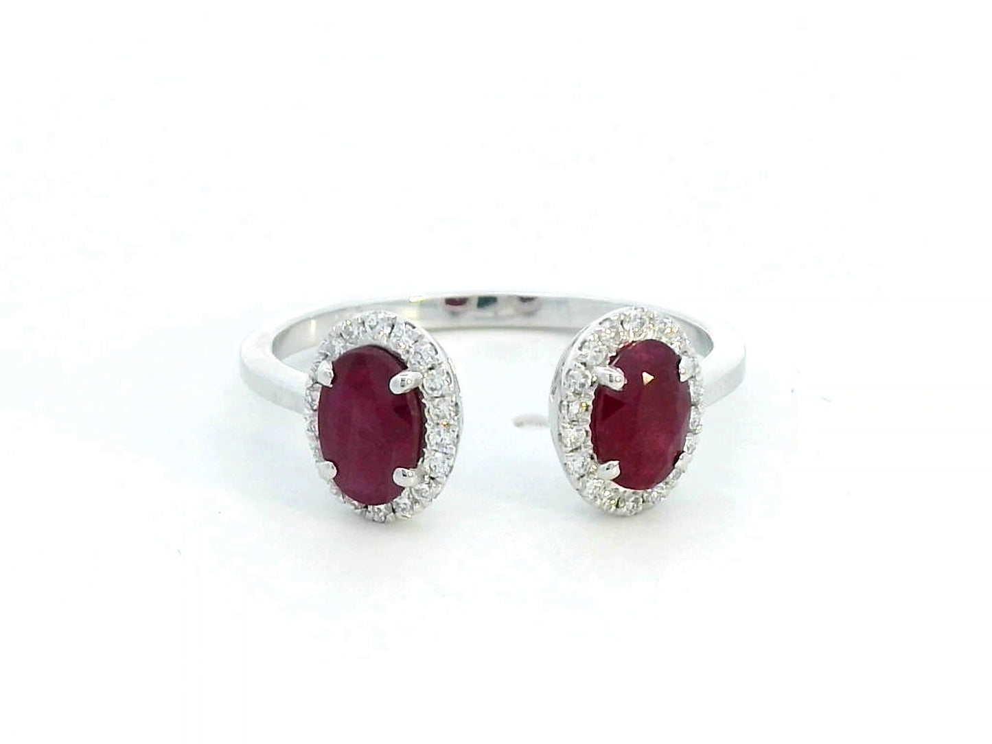 Elegant 18K gold bypass ring featuring two 1.07-carat oval rubies, accented by 0.17 carats of diamonds in a halo setting. A timeless statement piece