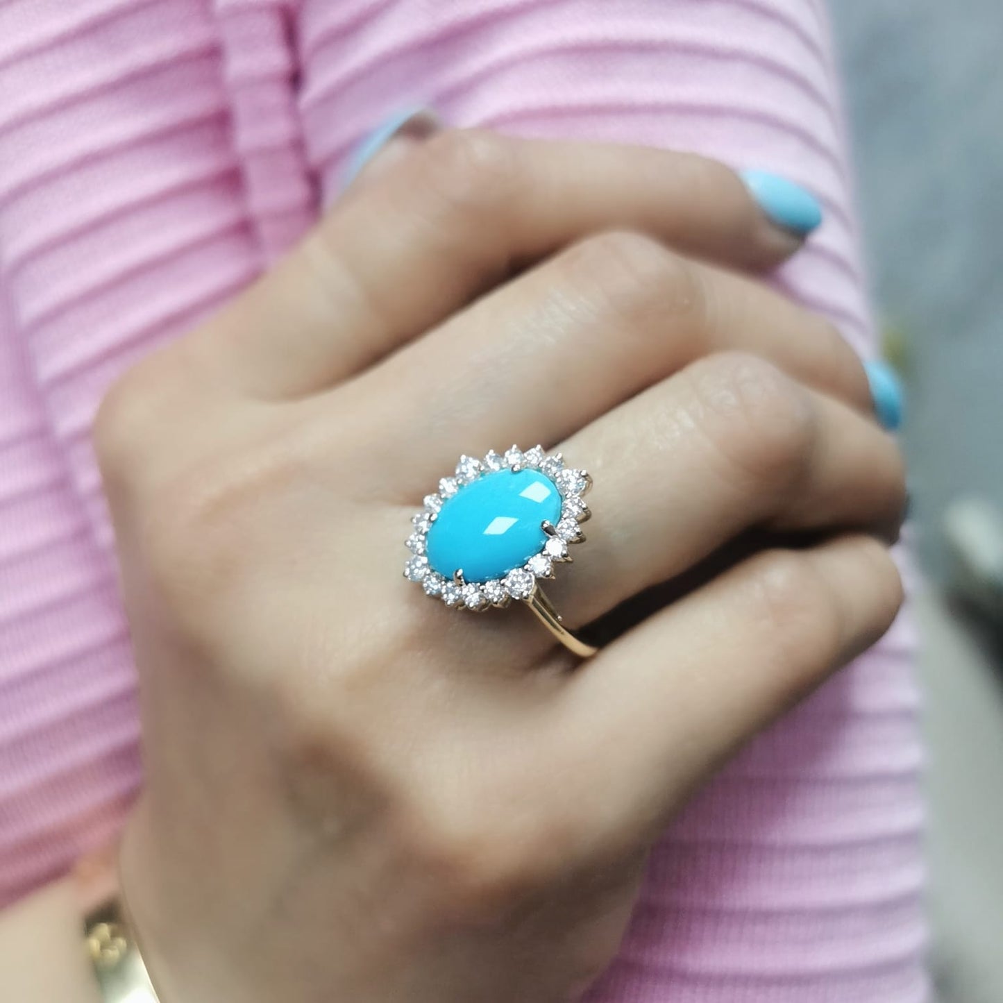 Elegant 18K gold ring featuring a 2.86-carat oval turquoise center stone, surrounded by a sparkling 0.69-carat diamond halo. A timeless statement piece.