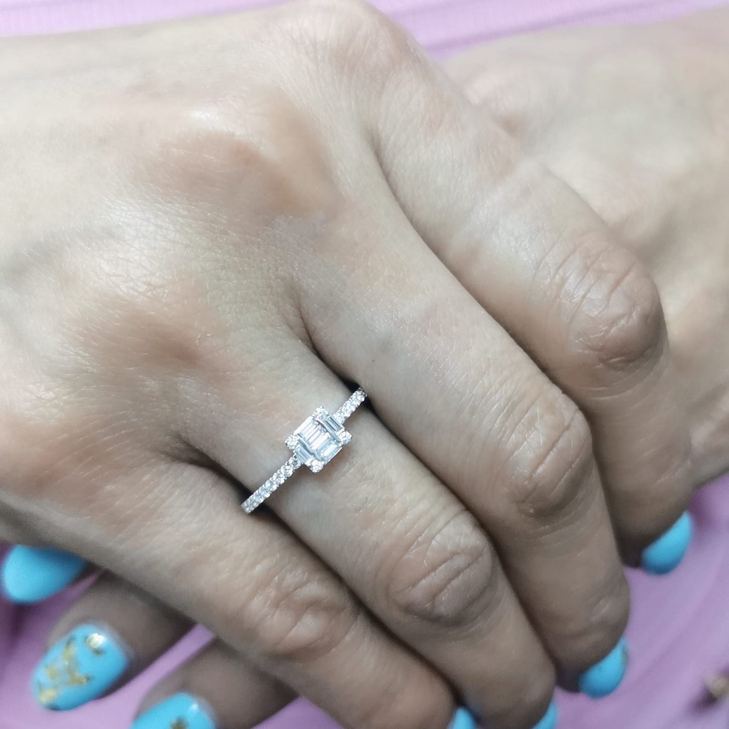 Delicate 18K gold ring featuring 0.28 carats of round and baguette diamonds, set on a diamond-studded band. A timeless piece for any occasion
