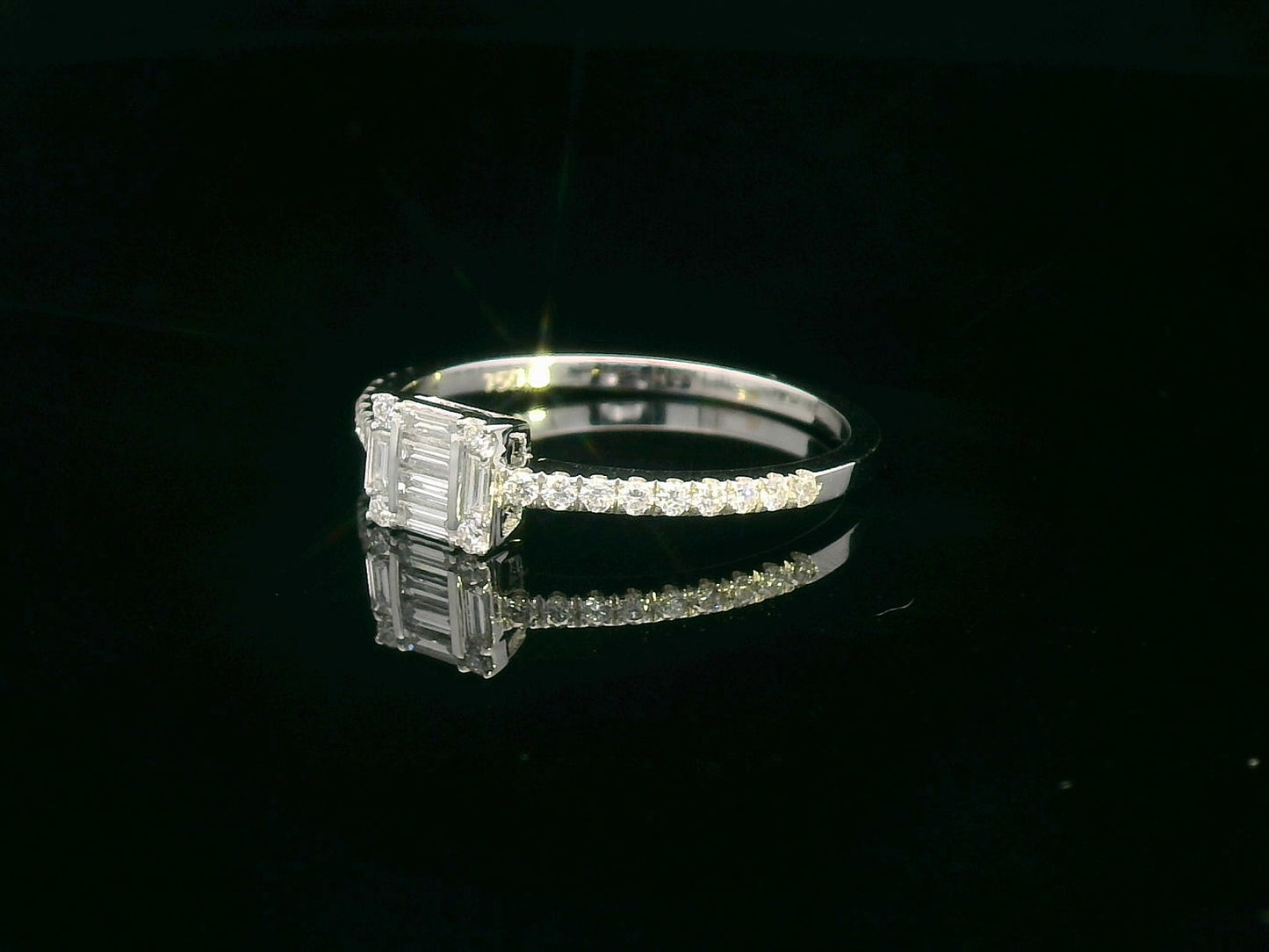 Delicate 18K gold ring featuring 0.28 carats of round and baguette diamonds, set on a diamond-studded band. A timeless piece for any occasion