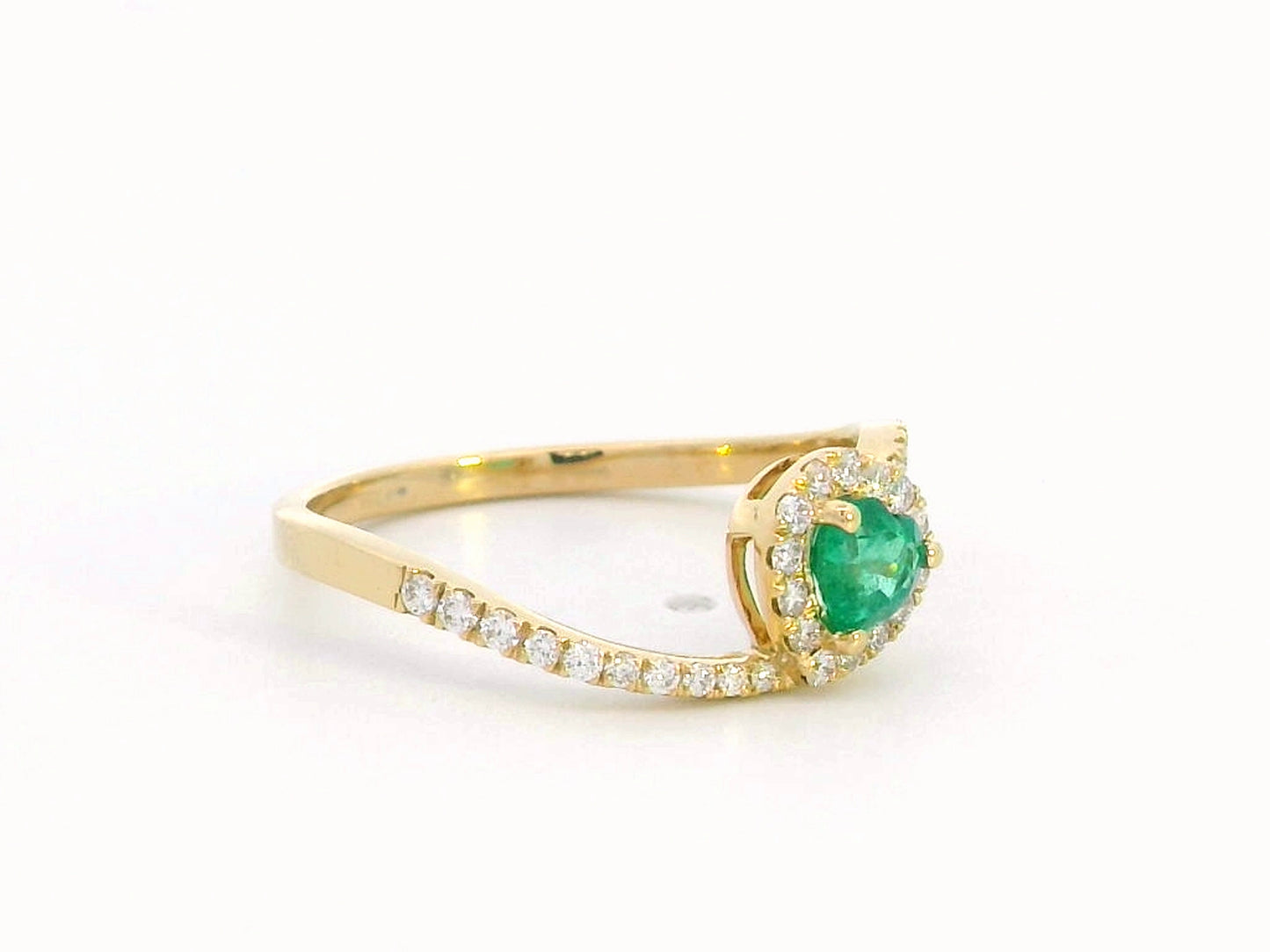 Heart-cut emerald ring with a diamond halo in 18K gold, featuring a bypass design for a timeless and elegant look.