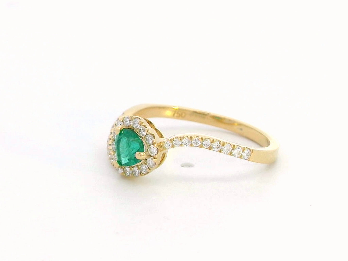 Heart-cut emerald ring with a diamond halo in 18K gold, featuring a bypass design for a timeless and elegant look.