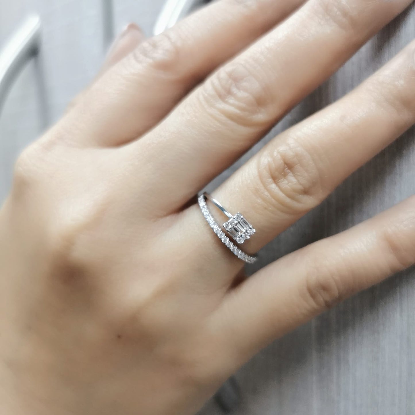18K gold ring with round and baguette diamonds, showcasing a modern asymmetrical split-band design.