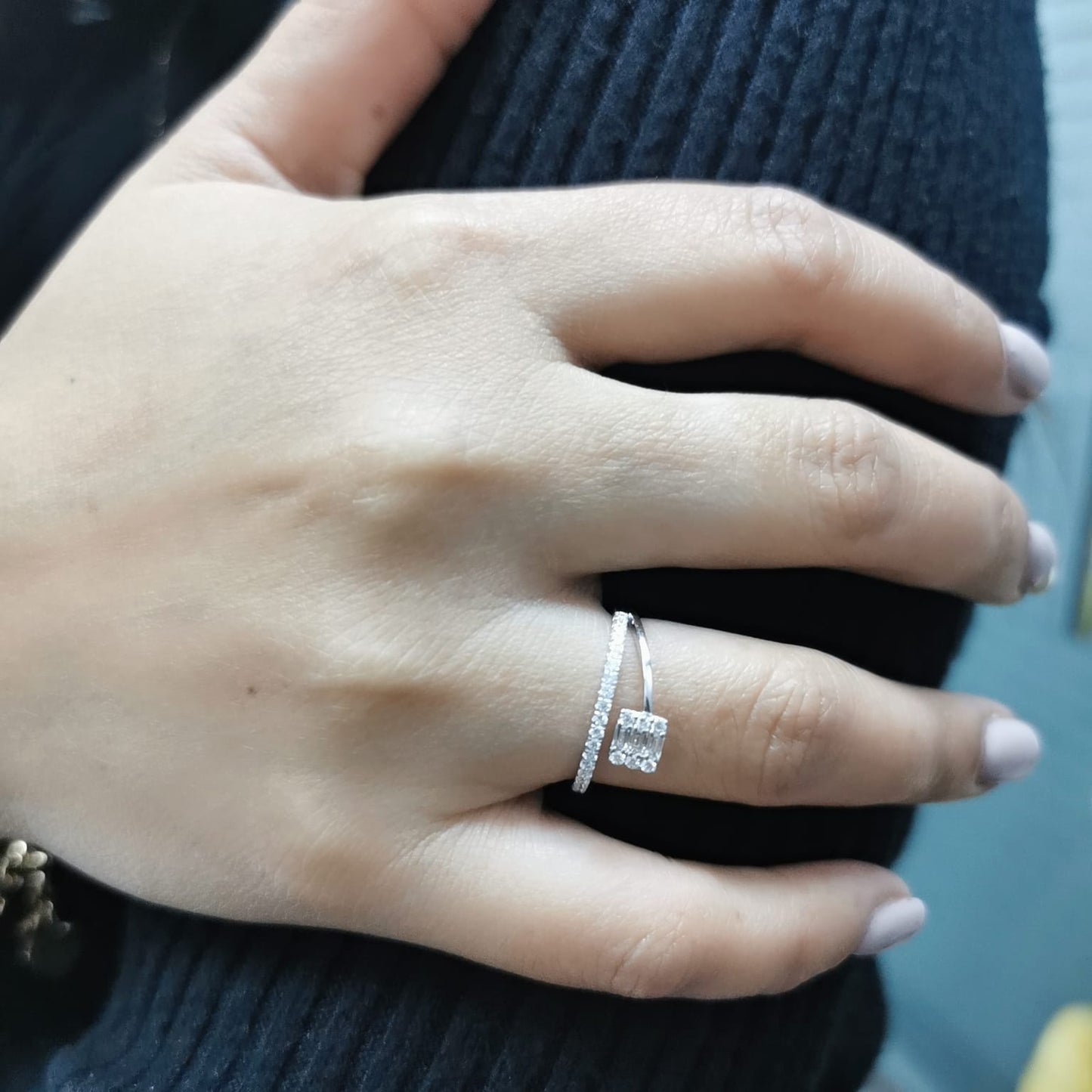 18K gold ring with round and baguette diamonds, showcasing a modern asymmetrical split-band design.