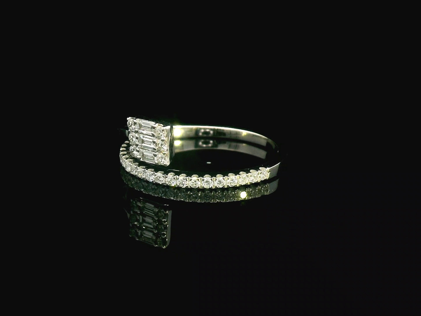 18K gold ring with round and baguette diamonds, showcasing a modern asymmetrical split-band design.