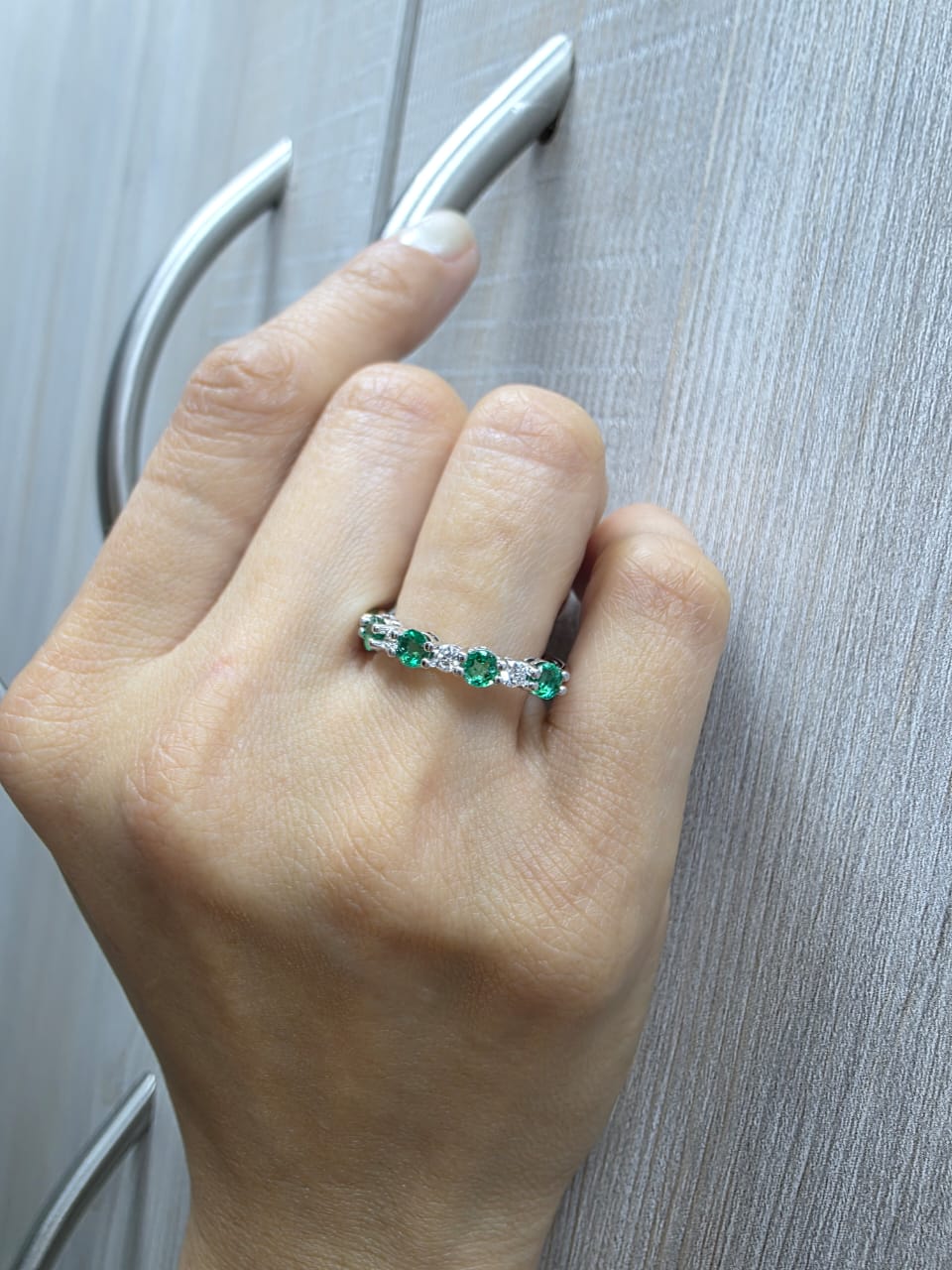 Elegant 18K white gold band with alternating round emeralds and diamonds – 0.94ct emeralds and 0.25ct diamonds.