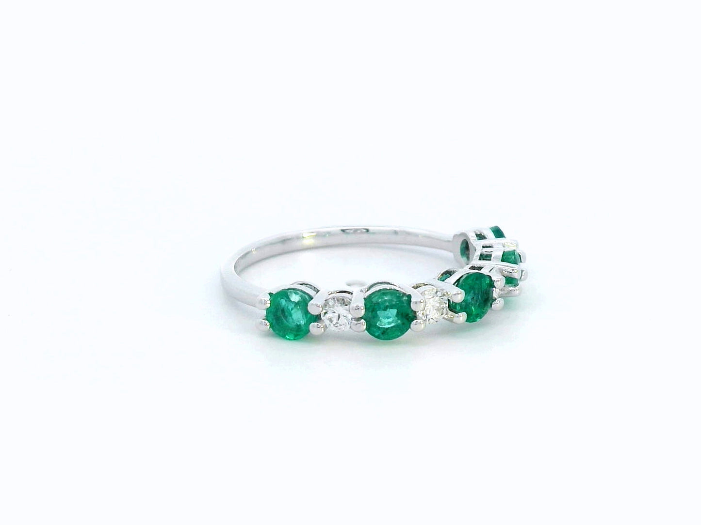 Elegant 18K white gold band with alternating round emeralds and diamonds – 0.94ct emeralds and 0.25ct diamonds.