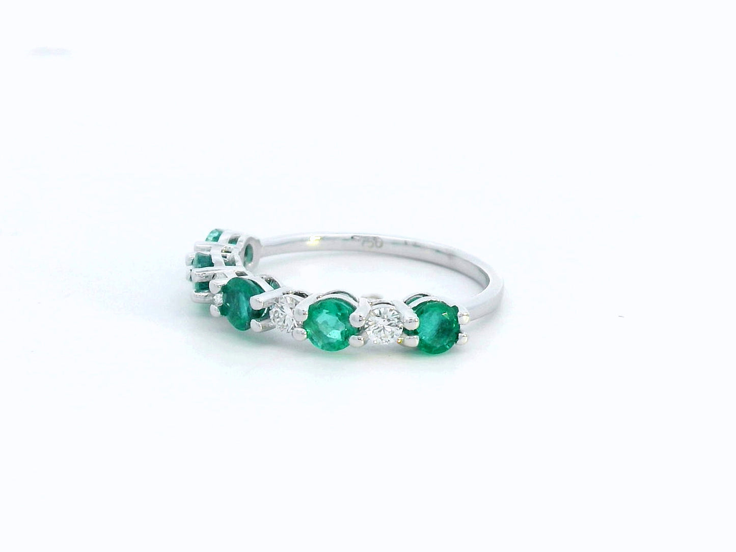 Elegant 18K white gold band with alternating round emeralds and diamonds – 0.94ct emeralds and 0.25ct diamonds.