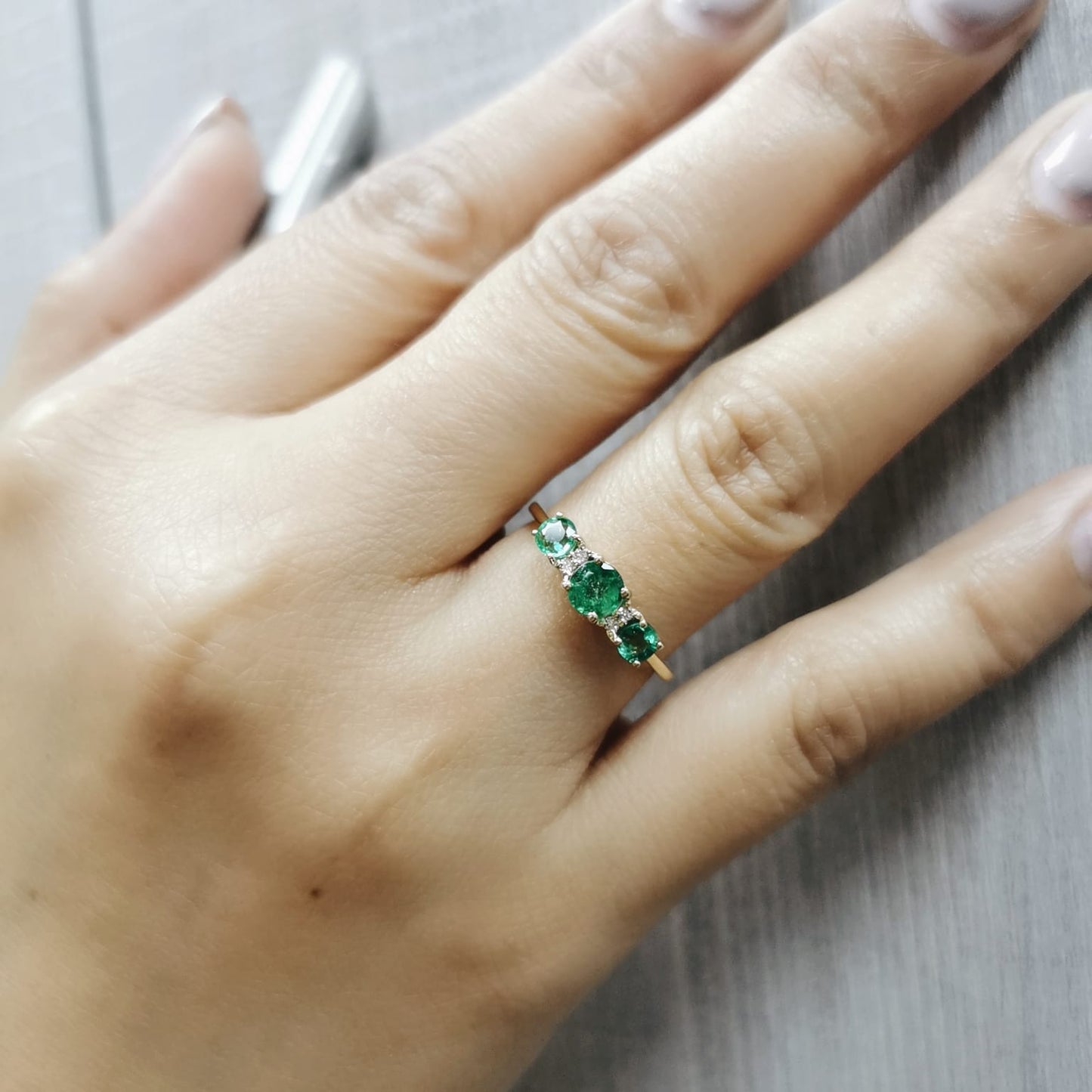 18K yellow gold emerald trilogy ring with diamond accents – 0.81ct emerald, 0.03ct diamond
