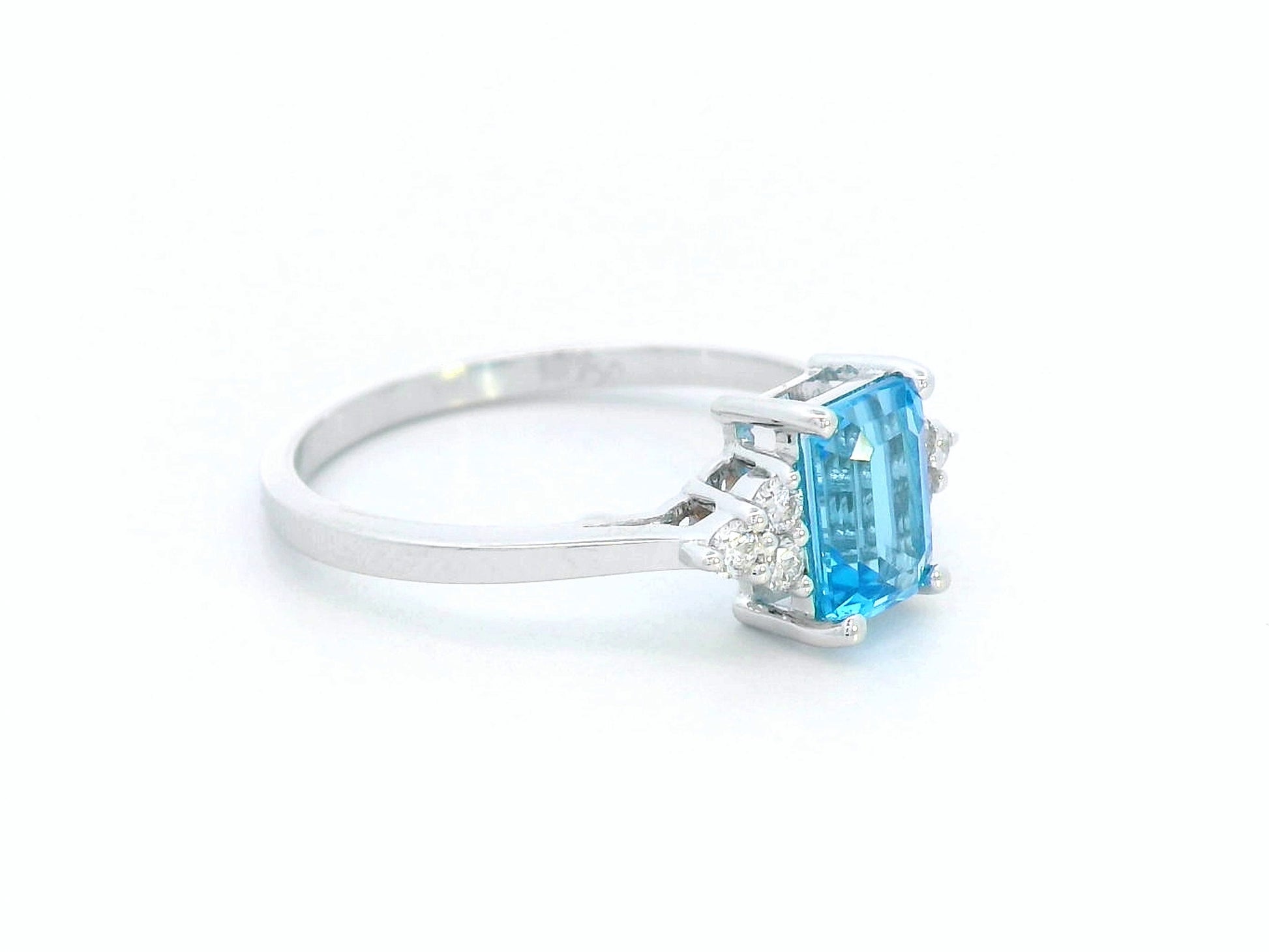 18K white gold ring with emerald-cut blue topaz and side diamond clusters – modern blue gemstone cocktail ring