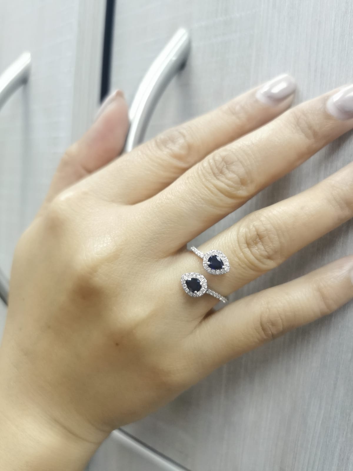 Pear-shaped sapphire and diamond bypass ring in 18K white gold with double halo design