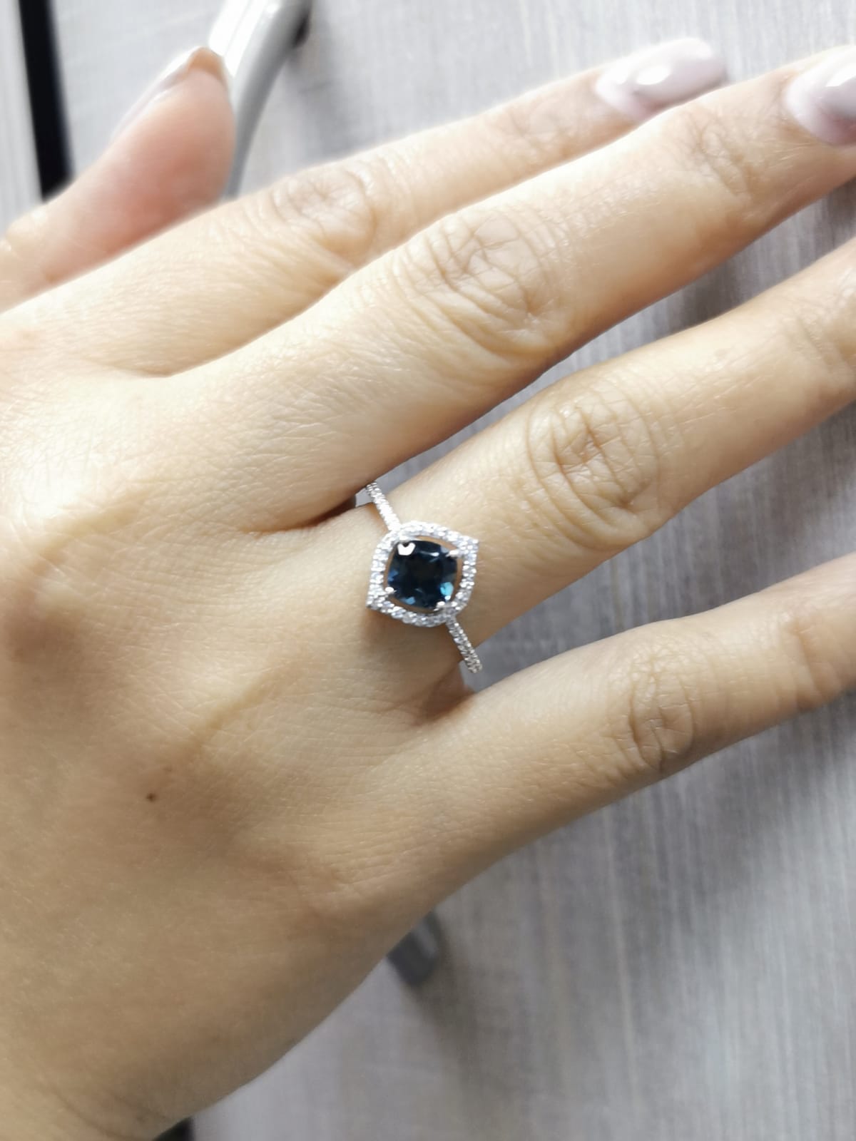 Cushion-cut London Blue Topaz ring with diamond halo and pavé diamond band in 18K gold