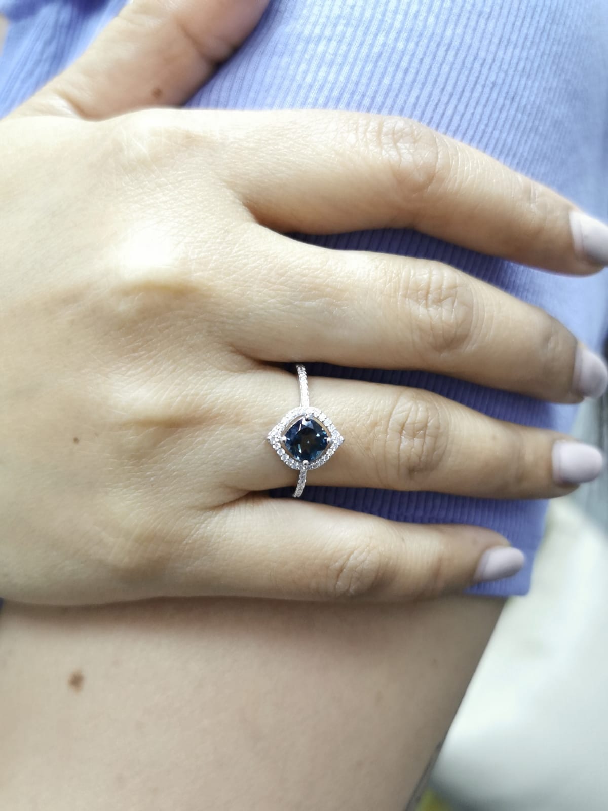 Cushion-cut London Blue Topaz ring with diamond halo and pavé diamond band in 18K gold