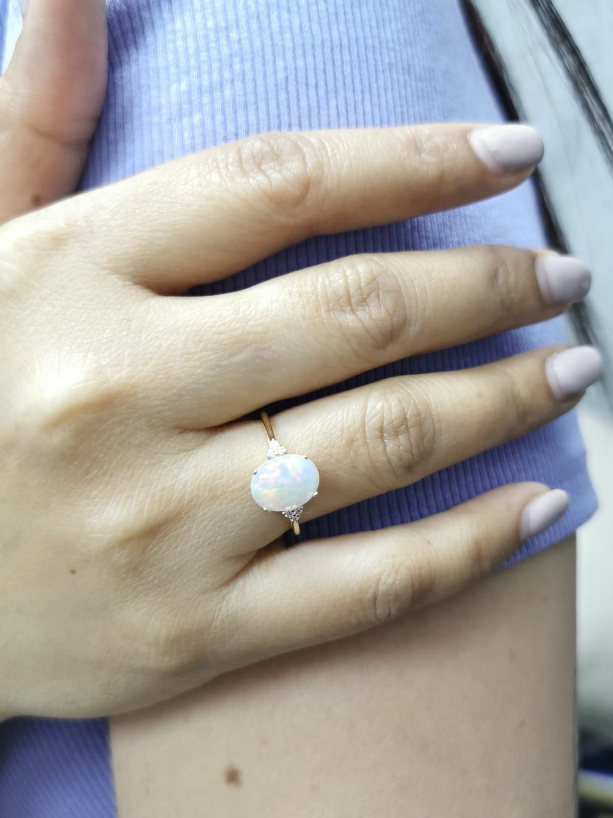 18K yellow gold ring with oval opal center flanked by accent diamonds.