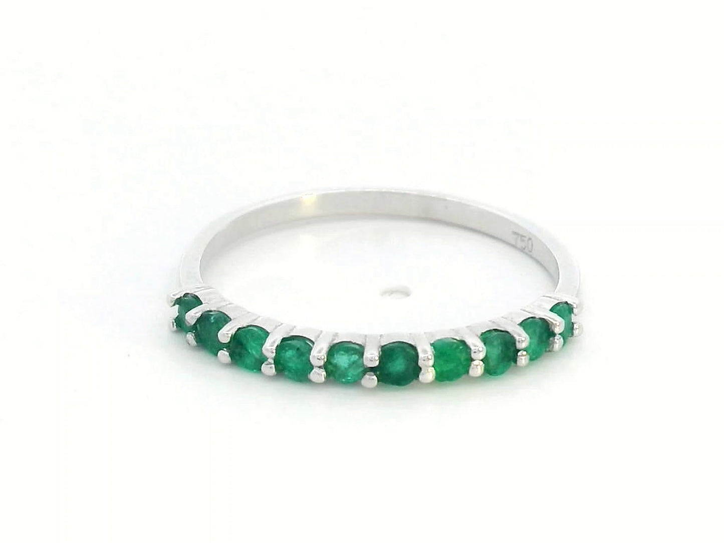 18K gold half-eternity ring with 0.42 carat round-cut emeralds in a prong setting.