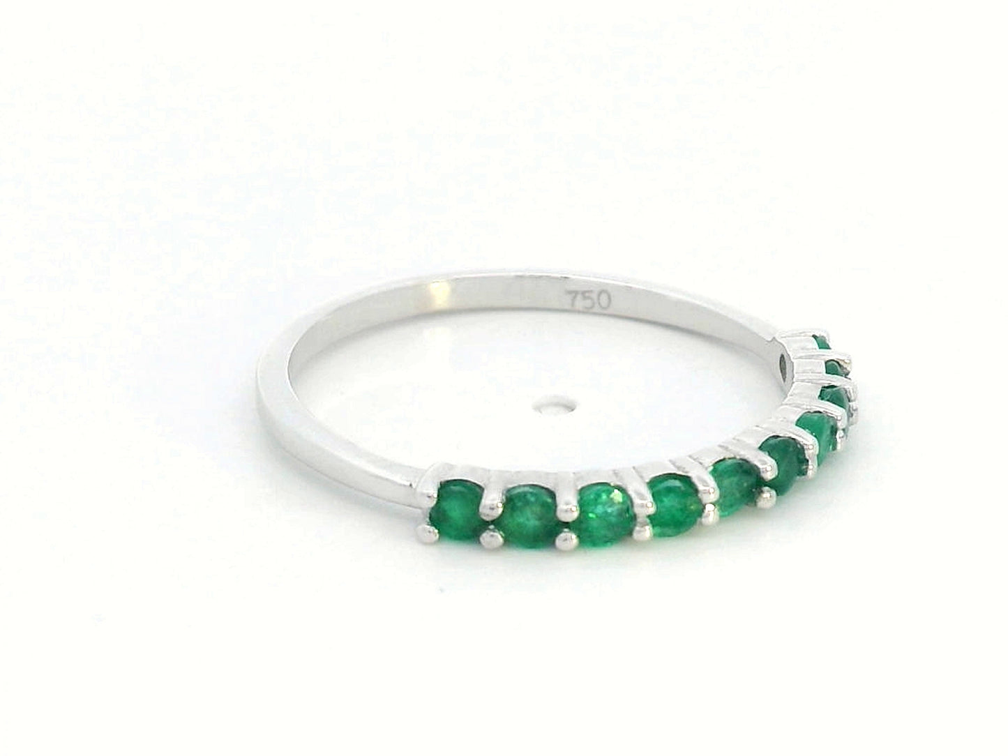 18K gold half-eternity ring with 0.42 carat round-cut emeralds in a prong setting.