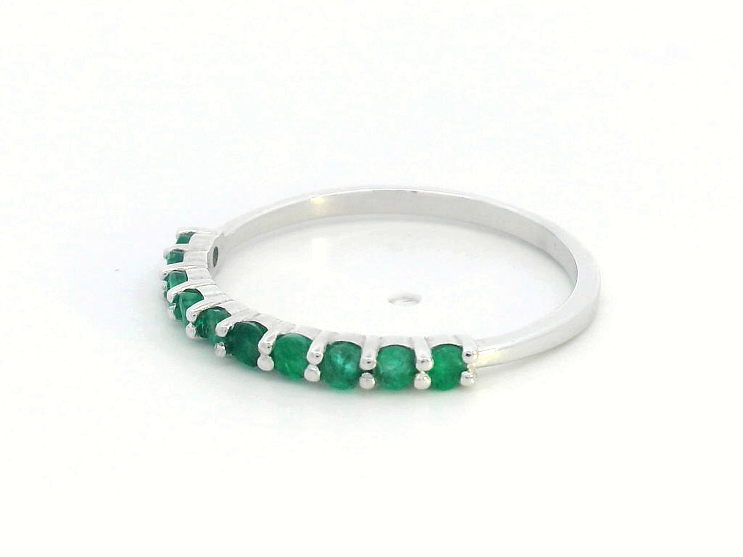 18K gold half-eternity ring with 0.42 carat round-cut emeralds in a prong setting.