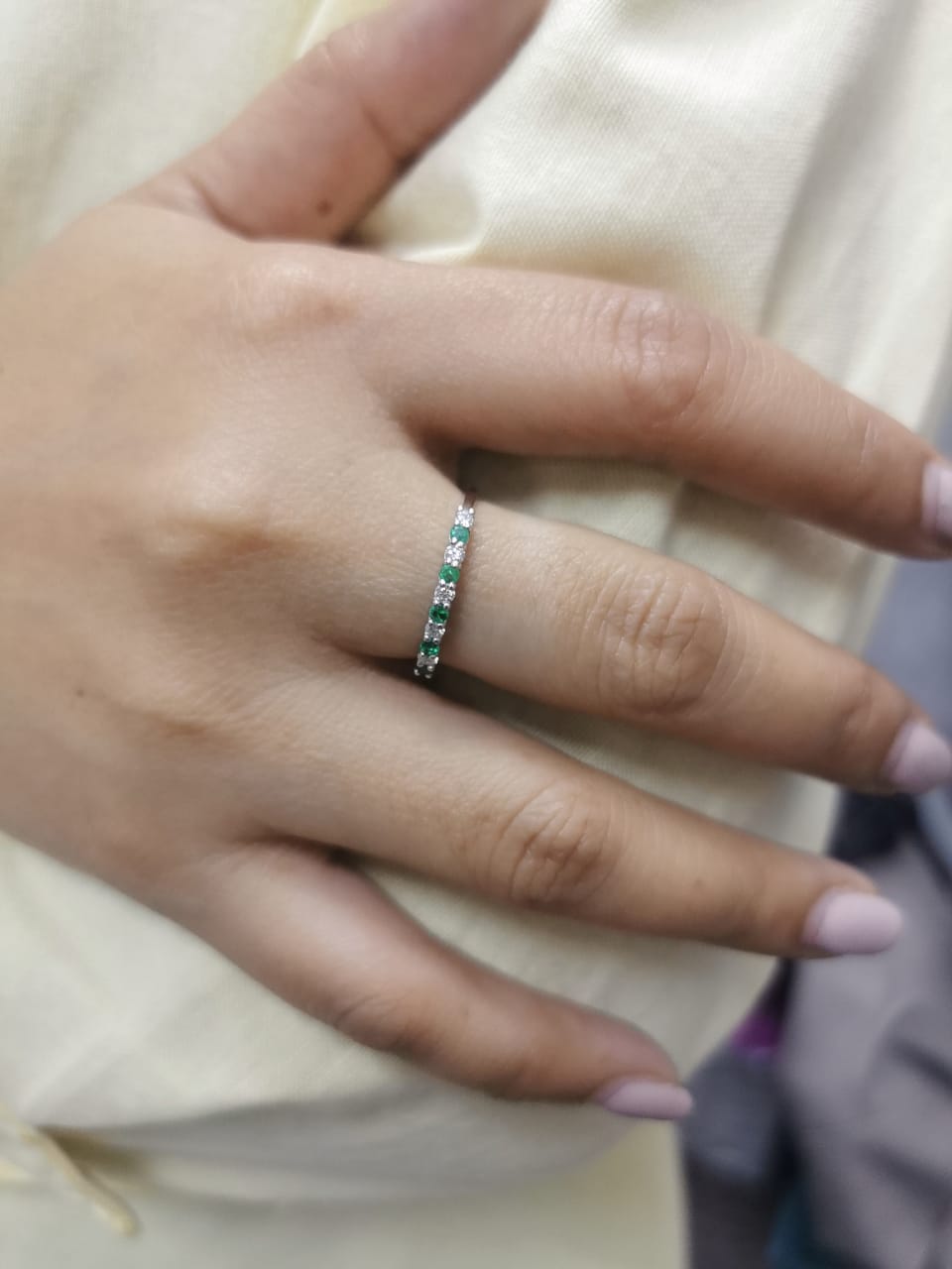 18K white gold half-eternity ring with alternating emeralds and diamonds, stackable wedding band design.