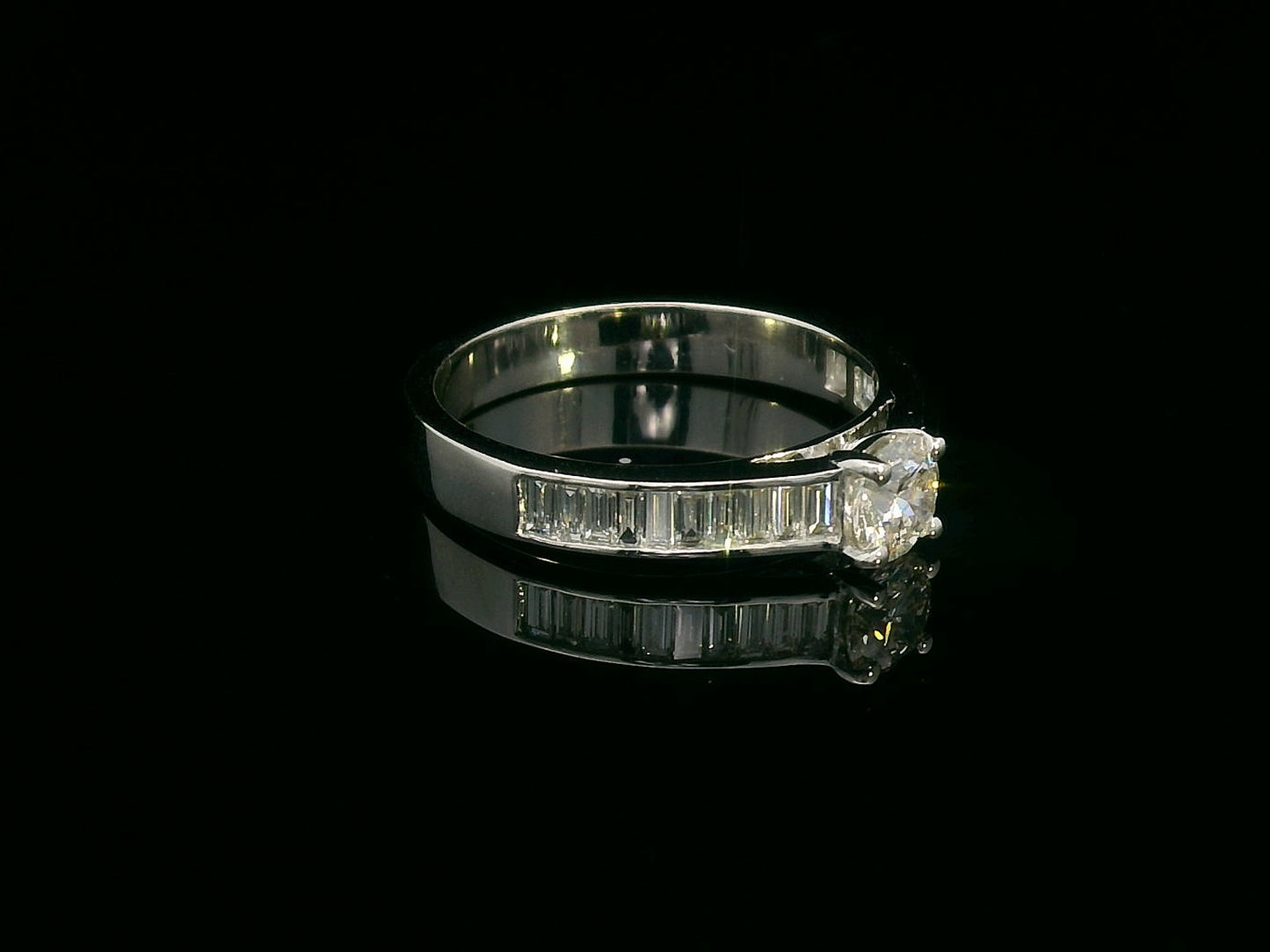 18K white gold engagement ring with round center diamond and baguette-cut side diamonds