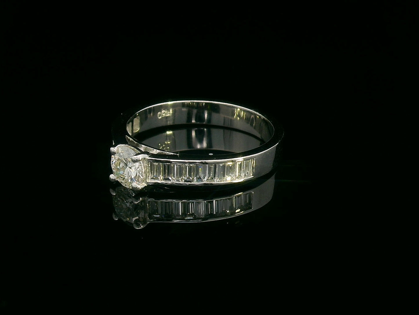 18K white gold engagement ring with round center diamond and baguette-cut side diamonds