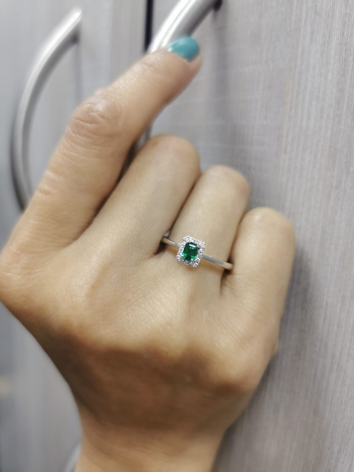 18K white gold ring with emerald-cut 0.36ct emerald and diamond halo – 0.07ct diamonds