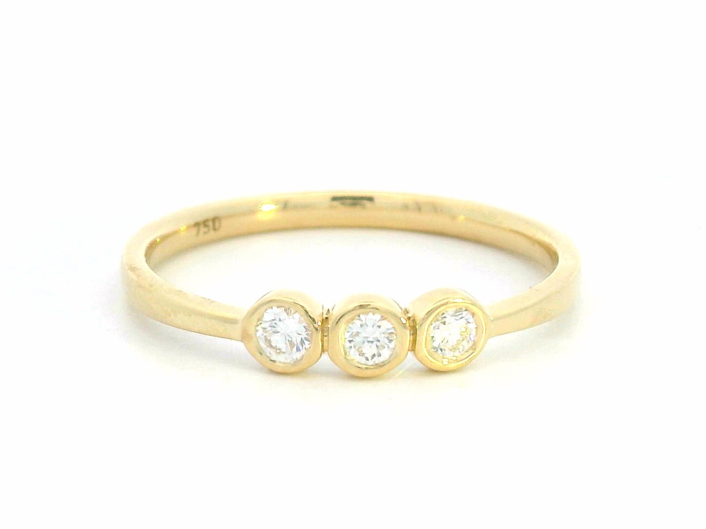 18K yellow gold trilogy ring with 0.18 carat bezel-set round diamonds, minimalist band design.