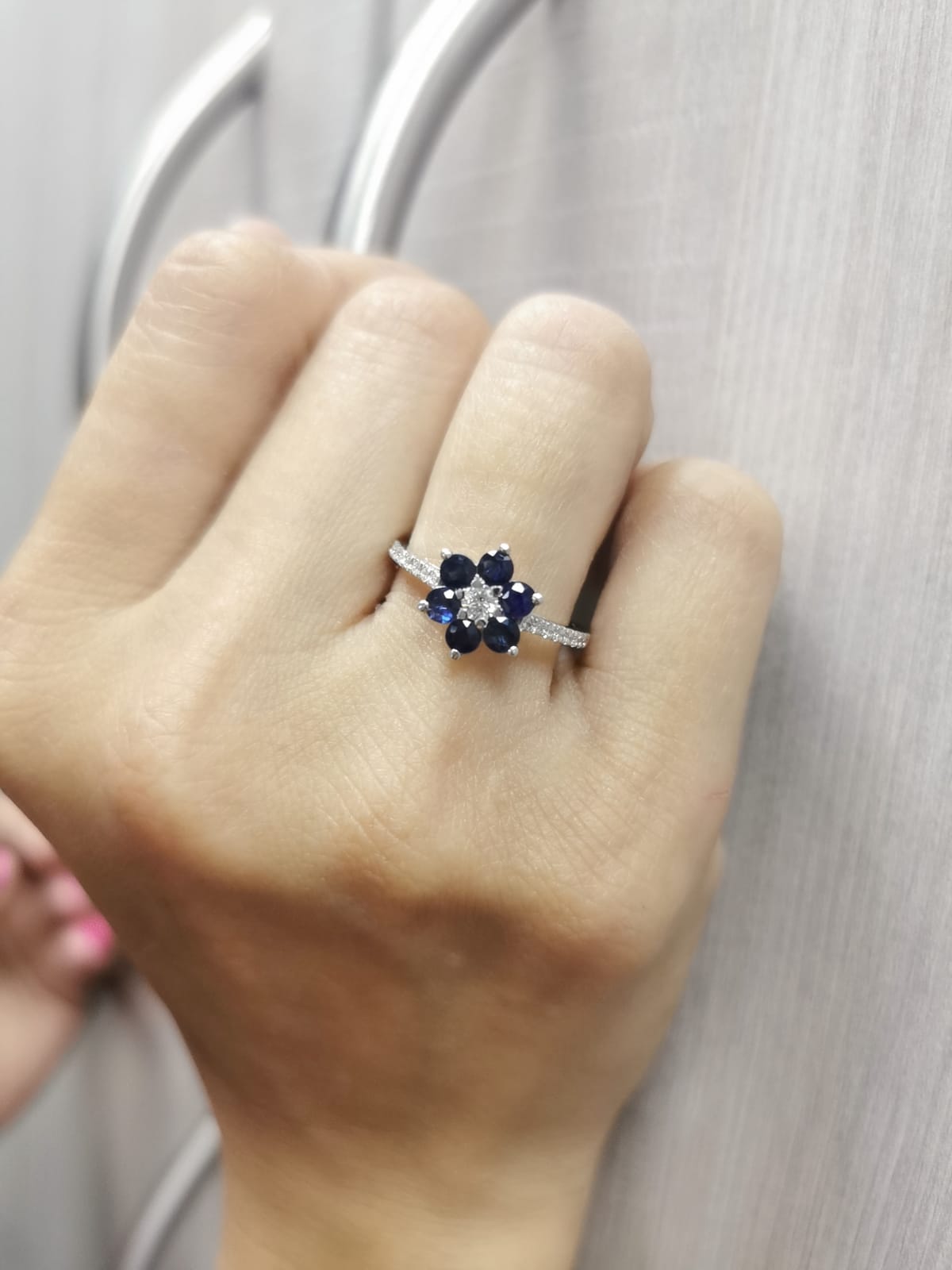 Floral ring in 18K gold with round blue sapphires and diamond center, pavé diamond band, total 0.91ct sapphires and 0.29ct diamonds.