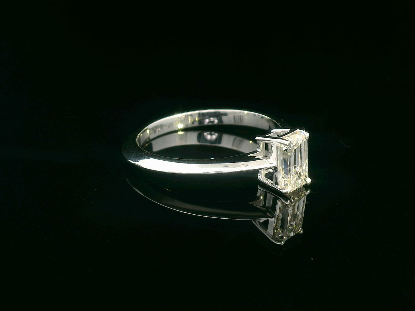 0.91 carat emerald cut diamond solitaire ring with knife-edge 18K gold band, minimalist and elegant design.