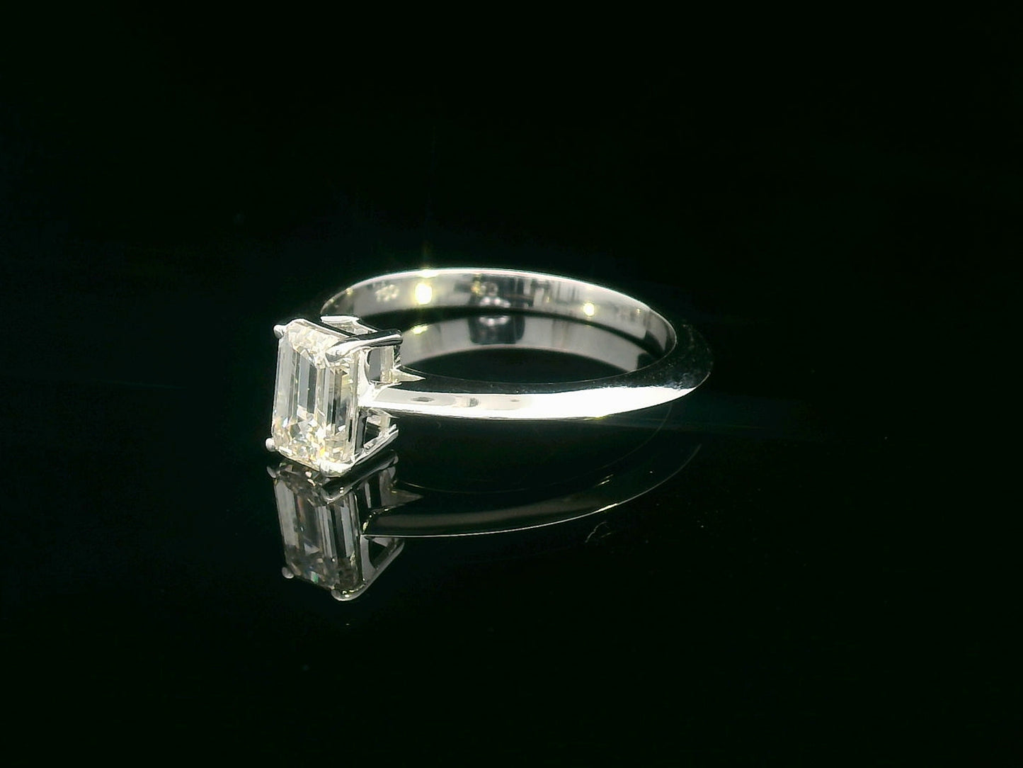 0.91 carat emerald cut diamond solitaire ring with knife-edge 18K gold band, minimalist and elegant design.