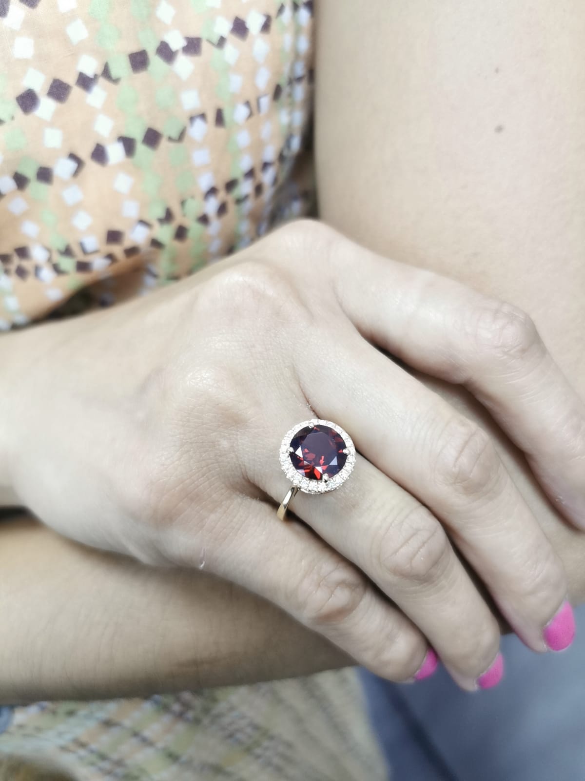 Round garnet and diamond halo ring in 18K yellow gold featuring a 3.85 carat garnet and 0.27 carats of diamonds.