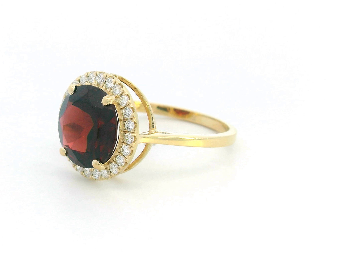 Round garnet and diamond halo ring in 18K yellow gold featuring a 3.85 carat garnet and 0.27 carats of diamonds.