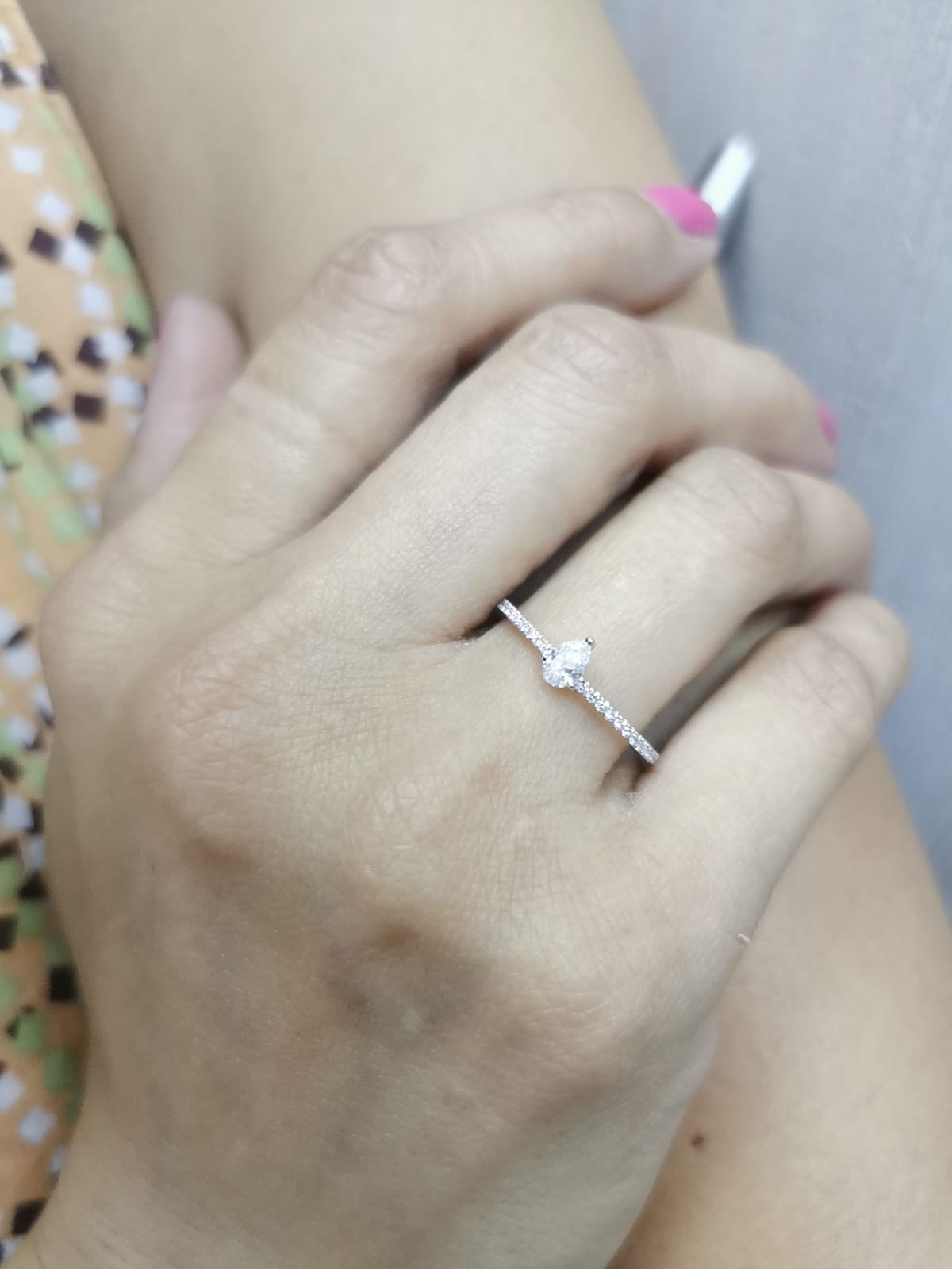 Slim 18K gold ring with pear-shaped diamond and pavé band, minimalist fine jewelry.