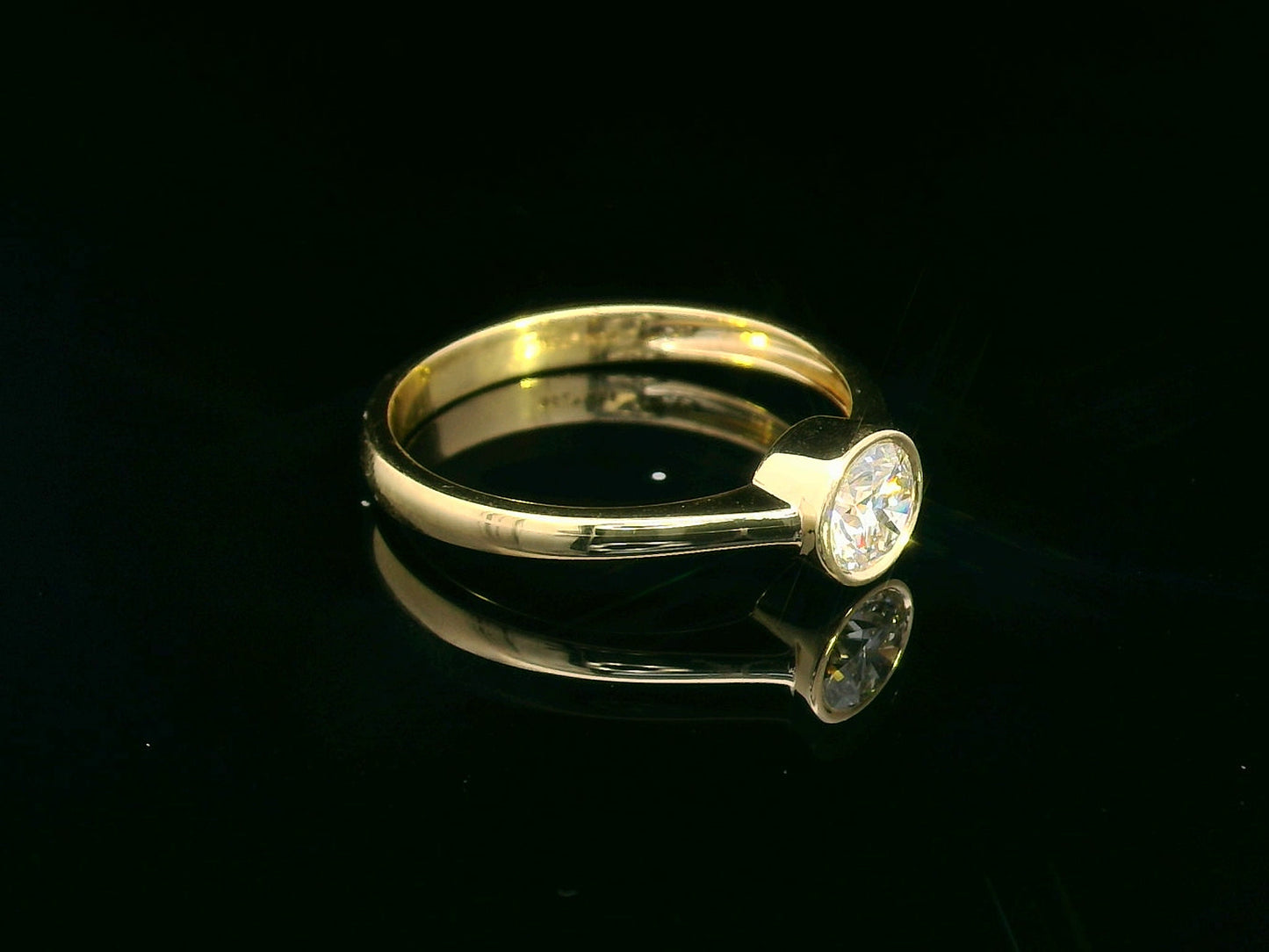 18K yellow gold solitaire ring with 0.51 carat round diamond in bezel setting