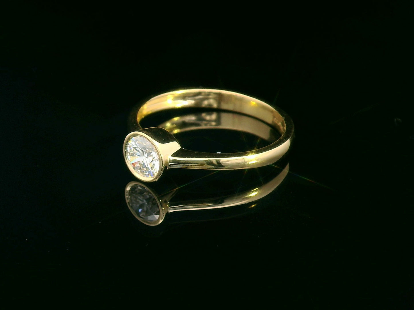 18K yellow gold solitaire ring with 0.51 carat round diamond in bezel setting