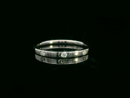 18K gold diamond band ring with flush-set round diamonds in a minimalist design