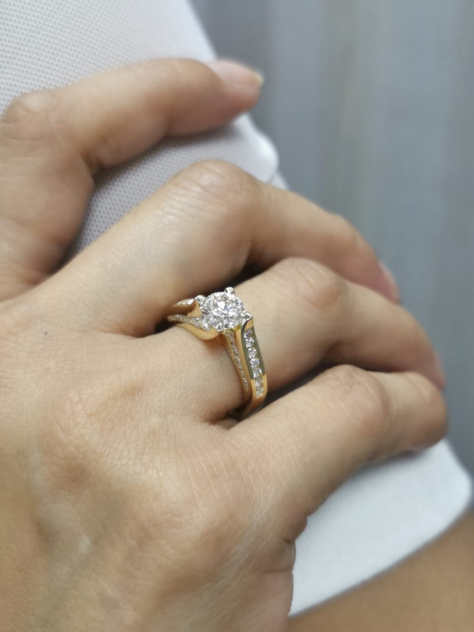 1.00ct round-cut diamond engagement ring in 18K yellow gold with 0.84ct channel-set side diamonds