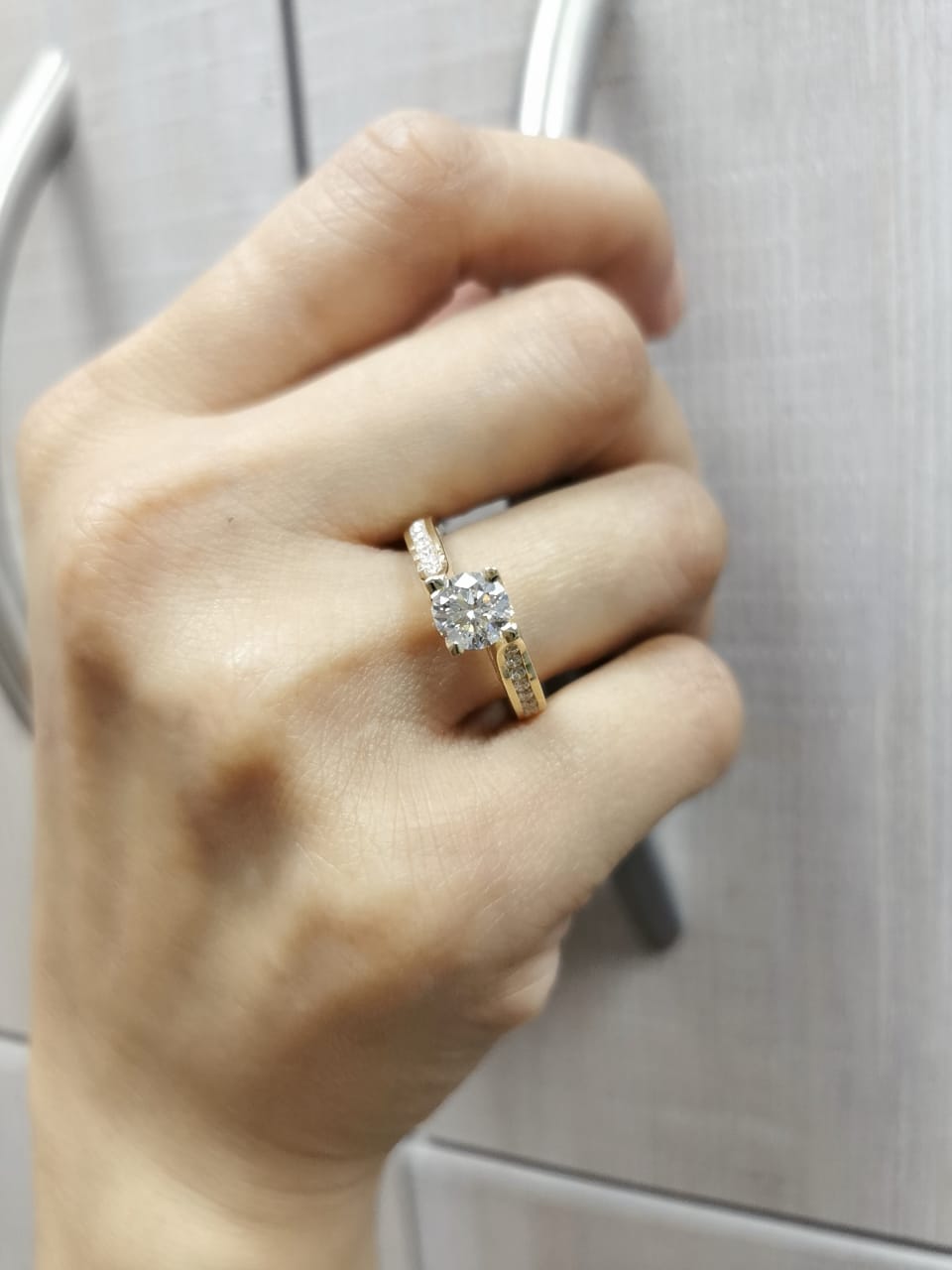 1.00ct round-cut diamond engagement ring in 18K yellow gold with 0.84ct channel-set side diamonds