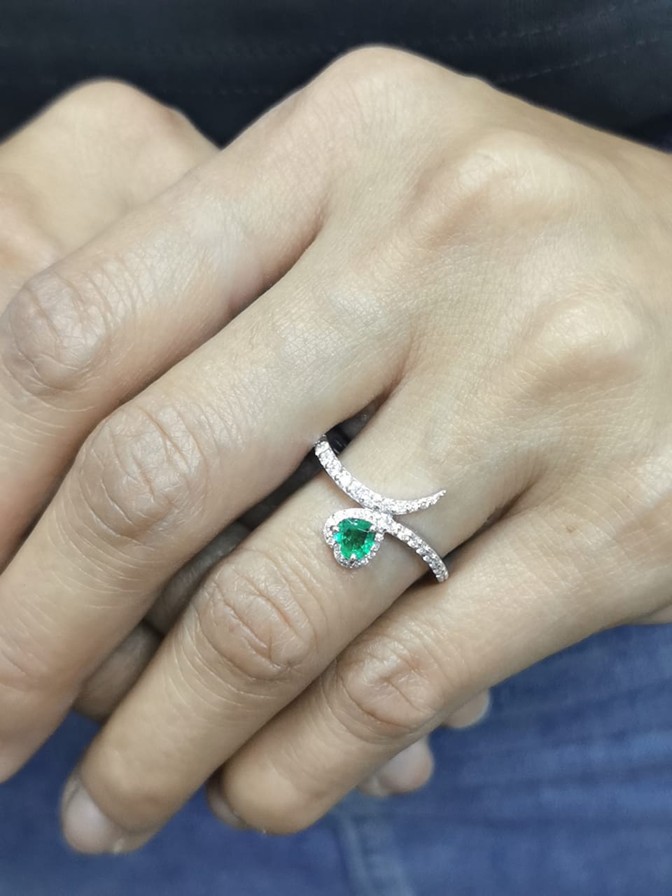 Heart-shaped emerald bypass ring in 18K white gold with diamond halo