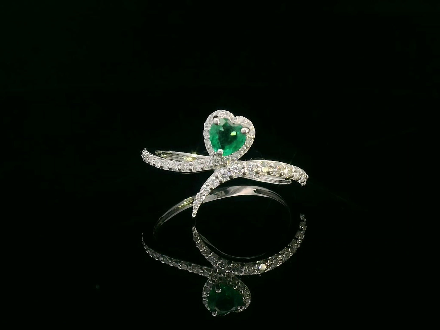 Heart-shaped emerald bypass ring in 18K white gold with diamond halo
