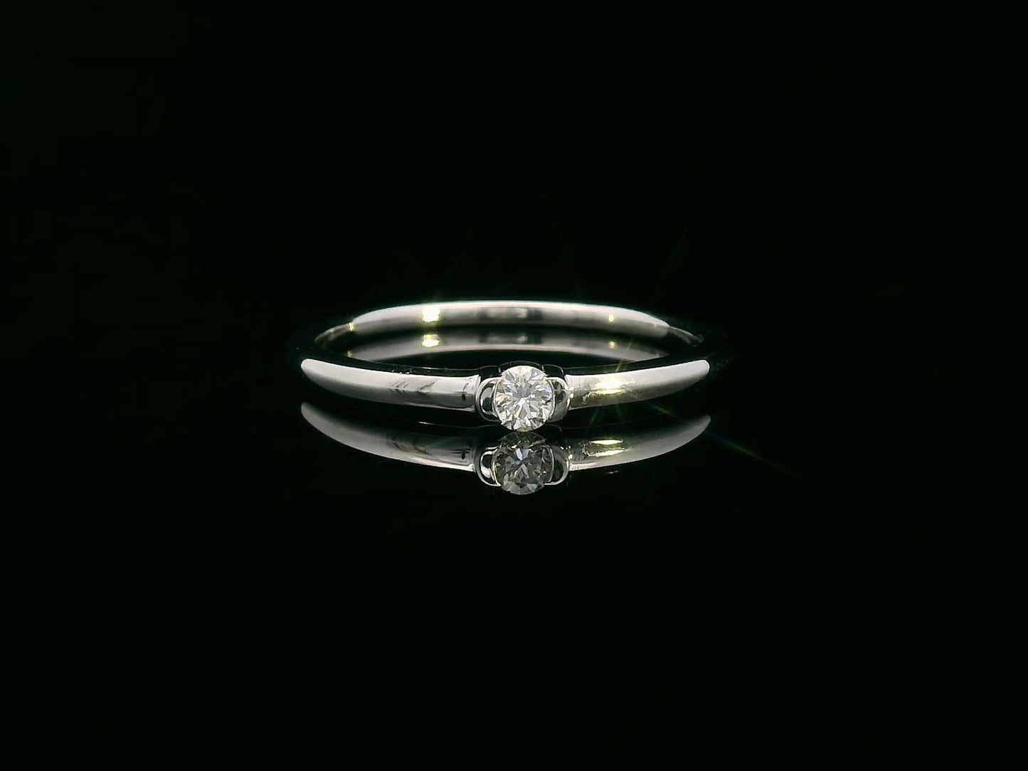 Modern minimalist tension-set diamond ring in 18K gold with 0.10ct solitaire