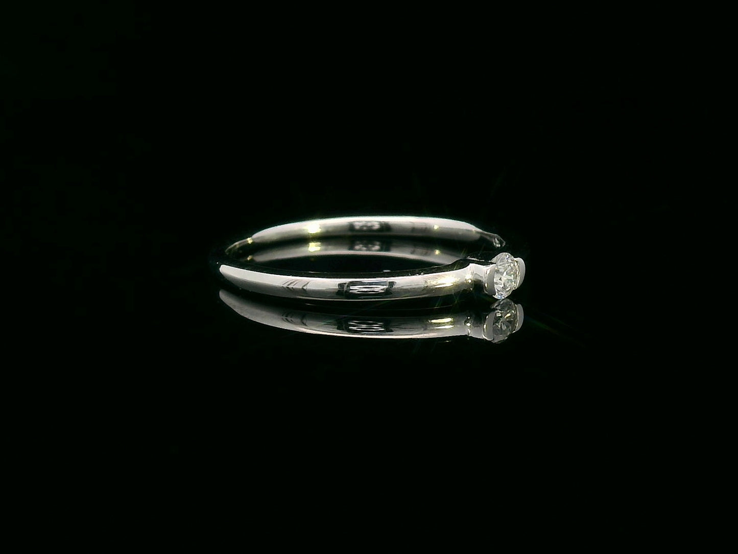 Modern minimalist tension-set diamond ring in 18K gold with 0.10ct solitaire