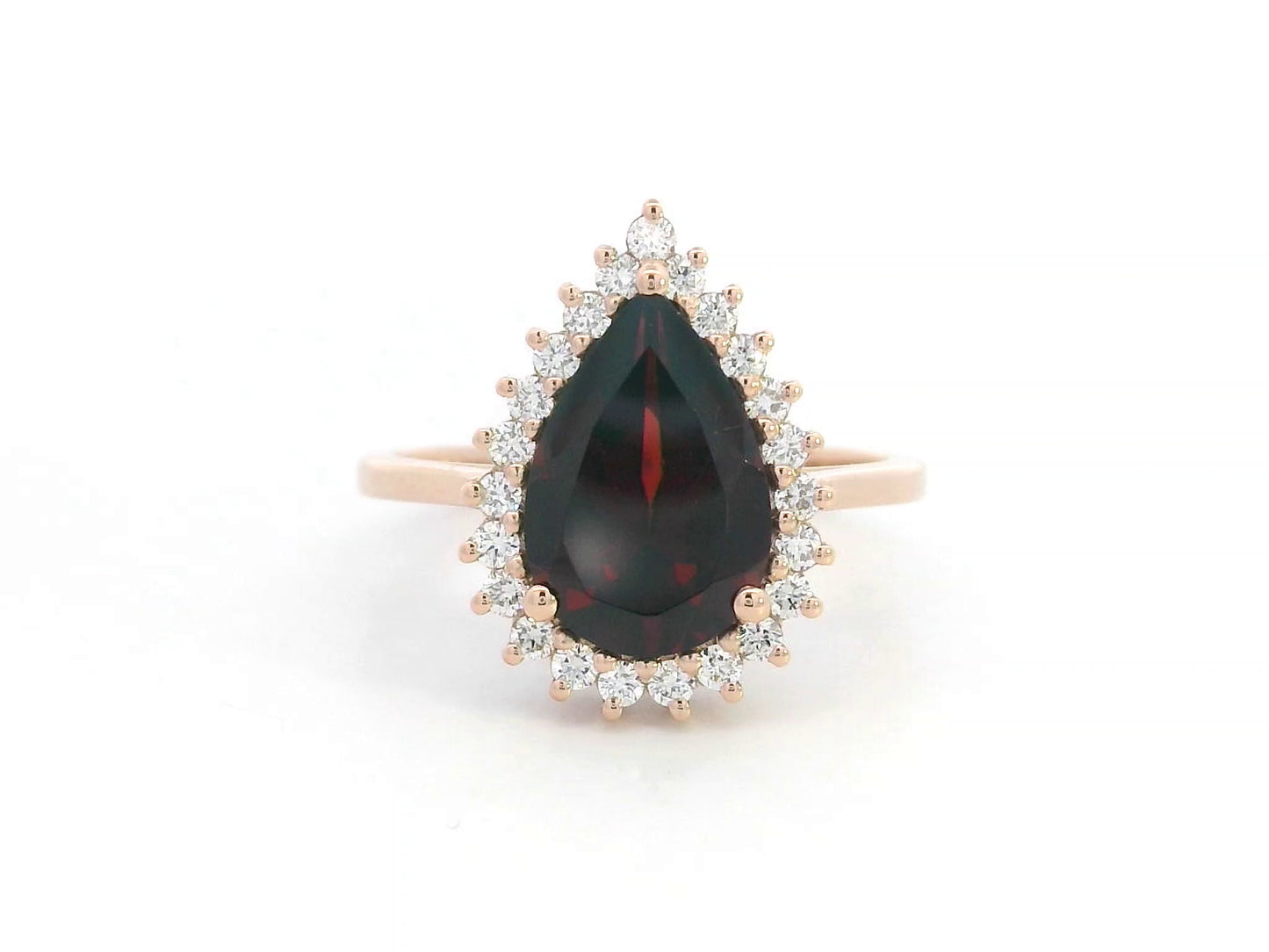 18K rose gold ring with pear-shaped garnet and starburst diamond halo setting