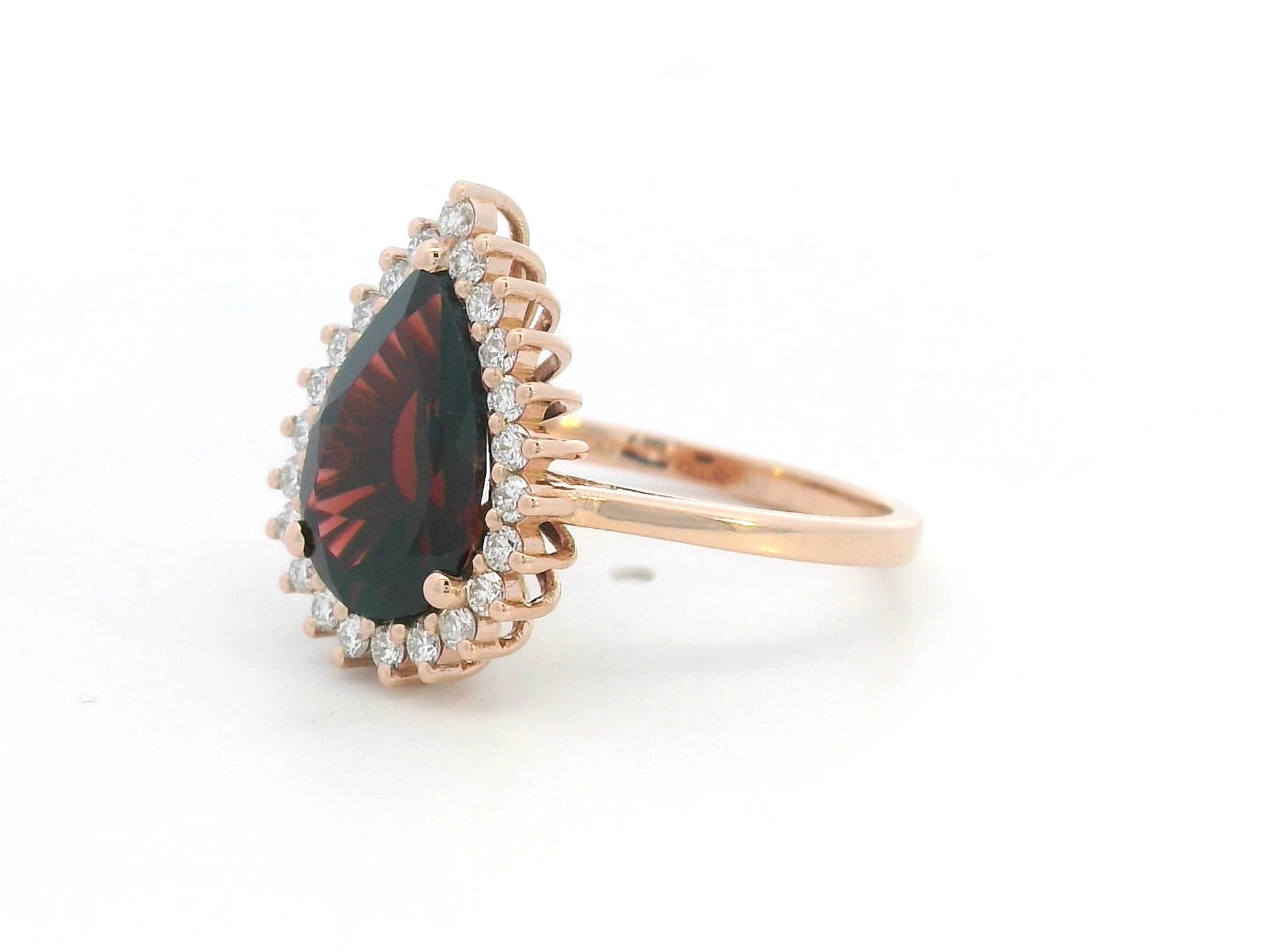 18K rose gold ring with pear-shaped garnet and starburst diamond halo setting