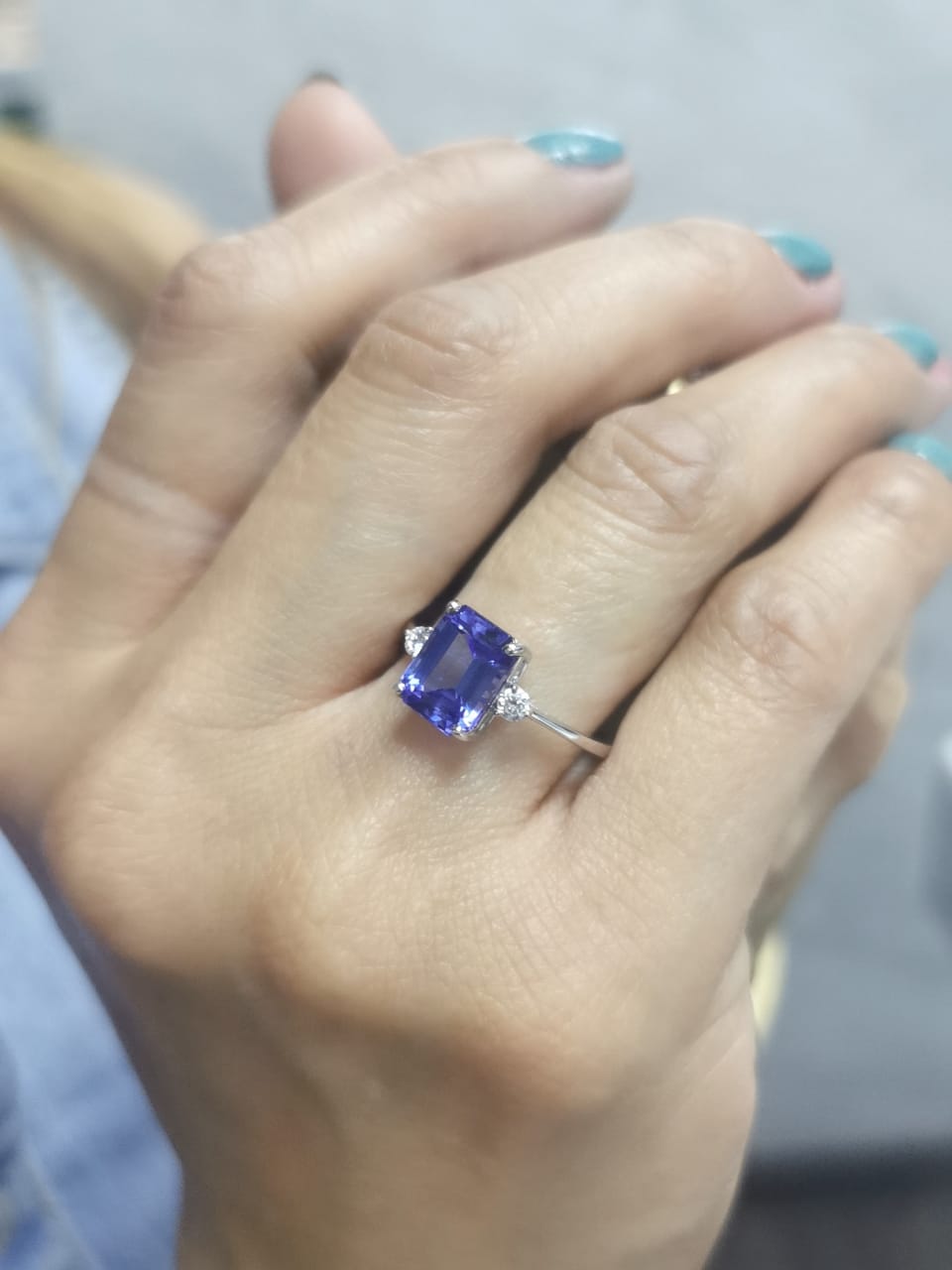 18K white gold ring with 3.08 carat emerald-cut Tanzanite and round diamond accents on the sides