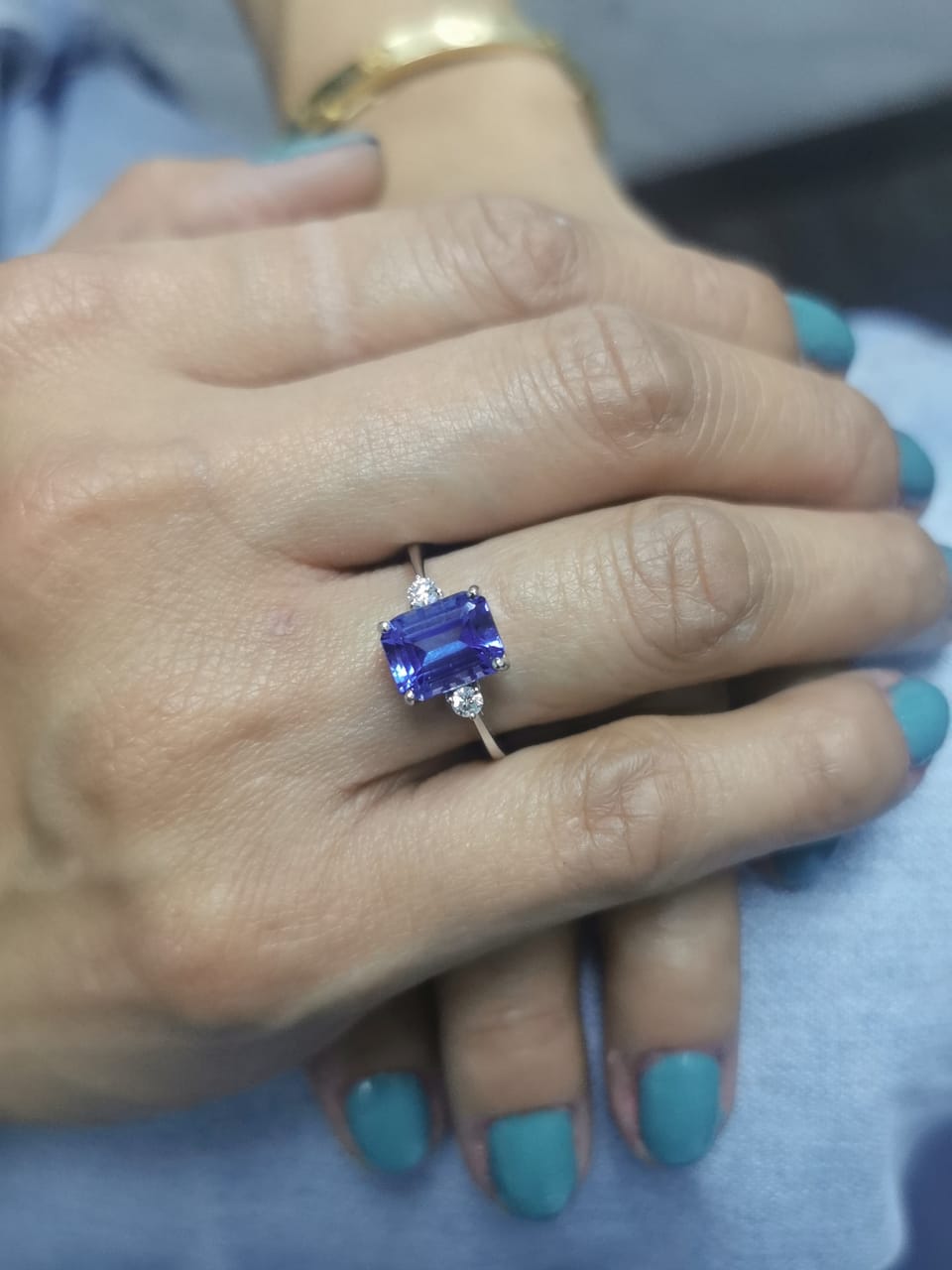 18K white gold ring with 3.08 carat emerald-cut Tanzanite and round diamond accents on the sides