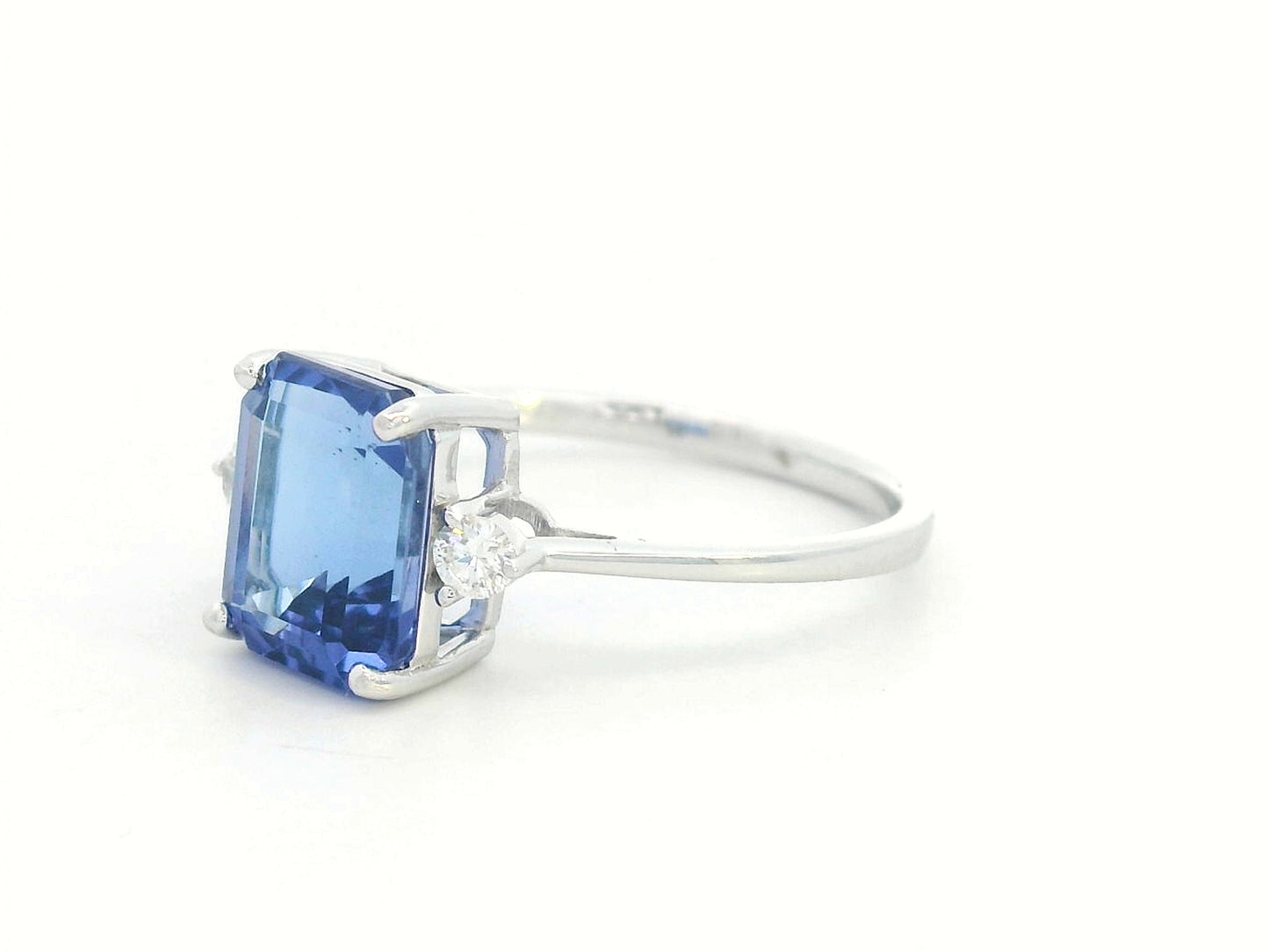 18K white gold ring with 3.08 carat emerald-cut Tanzanite and round diamond accents on the sides